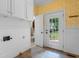Laundry room with white cabinets and an adjacent powder room near the rear door at 115 Ford Ave, Mullins, SC 29574