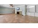 Open living room with tile flooring, fireplace, ceiling fan, and custom-built shelving and cabinets at 115 Ford Ave, Mullins, SC 29574
