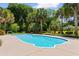 A private pool surrounded by a lush green yard and tropical landscaping, offering a serene retreat at 115 Ford Ave, Mullins, SC 29574