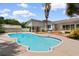 Outdoor pool area surrounded by concrete, landscaping, and the home's exterior with a greenhouse nearby at 115 Ford Ave, Mullins, SC 29574