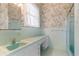 Bathroom with mint green tile, floral wallpaper, and large mirror at 118 Ford Ave, Mullins, SC 29574