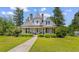 Charming two-story home with landscaped yard, inviting porch, and distinctive architectural details at 118 Ford Ave, Mullins, SC 29574