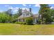 Charming two-story home with landscaped yard and inviting front porch nestled in lush greenery at 118 Ford Ave, Mullins, SC 29574