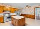 Traditional kitchen featuring stainless steel appliances, center island, and floral wallpaper at 118 Ford Ave, Mullins, SC 29574