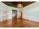 Open-concept living room with wood floors, light-green walls, chandelier, fireplace and french doors at 118 Ford Ave, Mullins, SC 29574