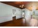 Large living room with wood floors, paneled walls, wood ceiling, chandelier, and multiple doorways at 118 Ford Ave, Mullins, SC 29574