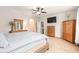 Well-lit main bedroom with hardwood furniture, an arched alcove, and a TV on the wall at 1367 Bermuda Grass Dr., Myrtle Beach, SC 29579