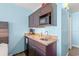 Kitchenette featuring granite countertops, dark cabinets, microwave, coffee maker, and a sink at 1501 S Ocean Blvd. # 501, Myrtle Beach, SC 29577