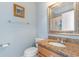 This bathroom features a pedestal sink with a granite countertop, decorative mirror, and white tile at 1516 James Island Ave., North Myrtle Beach, SC 29582