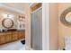 View of the shower and vanity featuring granite countertop, decorative mirror, and wood cabinets at 1516 James Island Ave., North Myrtle Beach, SC 29582