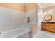 Bright bathroom featuring a soaking tub with white tile surround and granite countertop vanity at 1516 James Island Ave., North Myrtle Beach, SC 29582