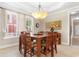 Elegant dining room with a large wood table, chandelier, and natural light from the window at 1516 James Island Ave., North Myrtle Beach, SC 29582