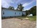 Light blue house with white trim, brick foundation, landscaped garden, and rear entrance at 1659 Sw Beach Dr., Sunset Beach, NC 28468