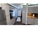 Galley kitchen with modern appliances, gray cabinetry, hardwood floors and view into hallway with decor at 1659 Sw Beach Dr., Sunset Beach, NC 28468