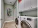 Well-lit laundry room with white washer and dryer, cabinets, tile flooring, and fresh pale green walls at 1903 Francis Ct., Myrtle Beach, SC 29577