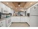 Well-lit kitchen boasts white appliances, ample counter space, and wooden ceiling at 2102 S Ocean Blvd. # D, North Myrtle Beach, SC 29582
