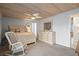 Comfortable main bedroom with wood ceiling, cozy rocking chair, and white wood furniture at 2102 S Ocean Blvd. # D, North Myrtle Beach, SC 29582