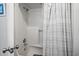 Walk-in shower with gray and white patterned shower curtain, seat, and showerhead at 2102 S Ocean Blvd. # D, North Myrtle Beach, SC 29582