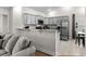 An open kitchen design with gray cabinets, stainless steel appliances, and a granite breakfast bar overlooking the living room at 224 Fishburn Dr., Conway, SC 29526