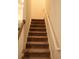 Carpeted staircase with white railings, providing a seamless transition between levels in the home at 224 Fishburn Dr., Conway, SC 29526