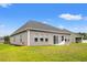 Backyard featuring lush green lawn and the home's exterior with multiple windows and a sliding glass door at 232 Red Maple Loop, Longs, SC 29568