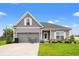 Charming two-story home with gray siding, an attached garage, and a well-manicured front yard with green lawn at 232 Red Maple Loop, Longs, SC 29568