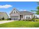 Charming single-Gathering home featuring a well-manicured lawn, gray siding, and a two-car garage at 232 Red Maple Loop, Longs, SC 29568