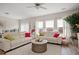 Well-lit living room with modern furnishings, large windows, and cozy rug at 232 Red Maple Loop, Longs, SC 29568
