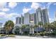 Exterior view of a coastal resort with unique architecture, lush landscaping, and palm trees at 2401 S Ocean Blvd. # 557, Myrtle Beach, SC 29577