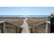Beach access stairs leading to the sandy shore and sparkling ocean waters at 2710 N Ocean Blvd. # 402, Myrtle Beach, SC 29577