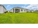 A bright backyard features a green lawn, a screened in porch with seating, and vinyl siding at 2757 Zenith Way, Myrtle Beach, SC 29577