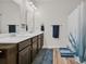 Bathroom features a double sink vanity, mirrors, and a shower-tub combo with a blue and white curtain at 2757 Zenith Way, Myrtle Beach, SC 29577