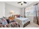 Bedroom with lots of light features a wood-frame bed, colorful accent chair, and neutral curtains at 2757 Zenith Way, Myrtle Beach, SC 29577