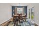 A dining room features a wooden table with six chairs, set on a patterned rug near sliding glass doors at 2757 Zenith Way, Myrtle Beach, SC 29577