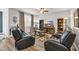 Spacious living room with hardwood flooring, ceiling fan, two black couches, and entertainment center at 2757 Zenith Way, Myrtle Beach, SC 29577