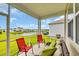 Covered patio with outdoor seating, lush green lawn and landscaping, with a view of the pond at 2757 Zenith Way, Myrtle Beach, SC 29577