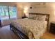 Comfortable bedroom with a patterned bedspread, lamps, and a large window with a view of the greenery at 306 Westbury Ct. # 2-B, Myrtle Beach, SC 29572