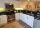 Galley kitchen featuring white cabinets, granite countertops, and stainless steel appliances at 306 Westbury Ct. # 2-B, Myrtle Beach, SC 29572