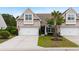Charming brick townhome with a two-car garage, mature palm tree, and well-maintained lawn and landscaping at 3334 Volterra Way # 3334, Myrtle Beach, SC 29579