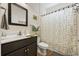 Bathroom with a sunflower shower curtain, dark wood vanity, framed mirror and a white toilet at 362 Shallow Cove Dr., Conway, SC 29527