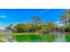 Scenic view of a serene pond with lush greenery and community buildings at 415 Ocean Creek Dr. # 2245, Myrtle Beach, SC 29572