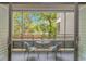 Screened porch features a cozy seating area with a small table and scenic outdoor views at 415 Ocean Creek Dr. # 2245, Myrtle Beach, SC 29572