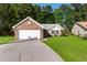 Inviting brick and vinyl home with a well-maintained lawn and long driveway leading to a two-car garage at 4171 Wrens Crossing, Little River, SC 29566