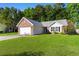 Charming brick and vinyl home featuring a well-manicured lawn and attached two-car garage at 4171 Wrens Crossing, Little River, SC 29566