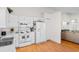 Well-lit kitchen with white appliances and cabinetry, adjacent to the living area at 4171 Wrens Crossing, Little River, SC 29566