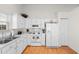 Bright kitchen features white appliances, cabinets, and laminate wood flooring at 4171 Wrens Crossing, Little River, SC 29566