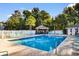 Outdoor pool area with ample seating surrounded by lush greenery at 4171 Wrens Crossing, Little River, SC 29566