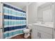 Clean bathroom with a striped shower curtain, white vanity, and wood-look flooring at 4359 Livorn Loop # 4359, Myrtle Beach, SC 29579
