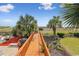 A wooden walkway leads to the beach surrounded by palm trees, lush greenery, and sitting areas at 4501 S Ocean Blvd., North Myrtle Beach, SC 29582