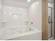 A bright bathroom showing a relaxing jet tub, recessed lighting, and a glass-enclosed shower at 4501 S Ocean Blvd., North Myrtle Beach, SC 29582